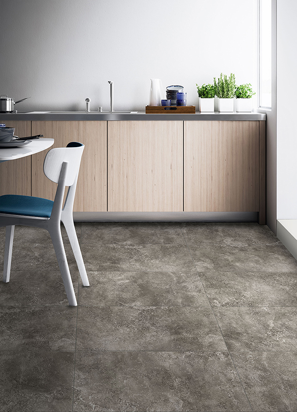 A bright and clean kitchen that has faux stone tiling on the floor.